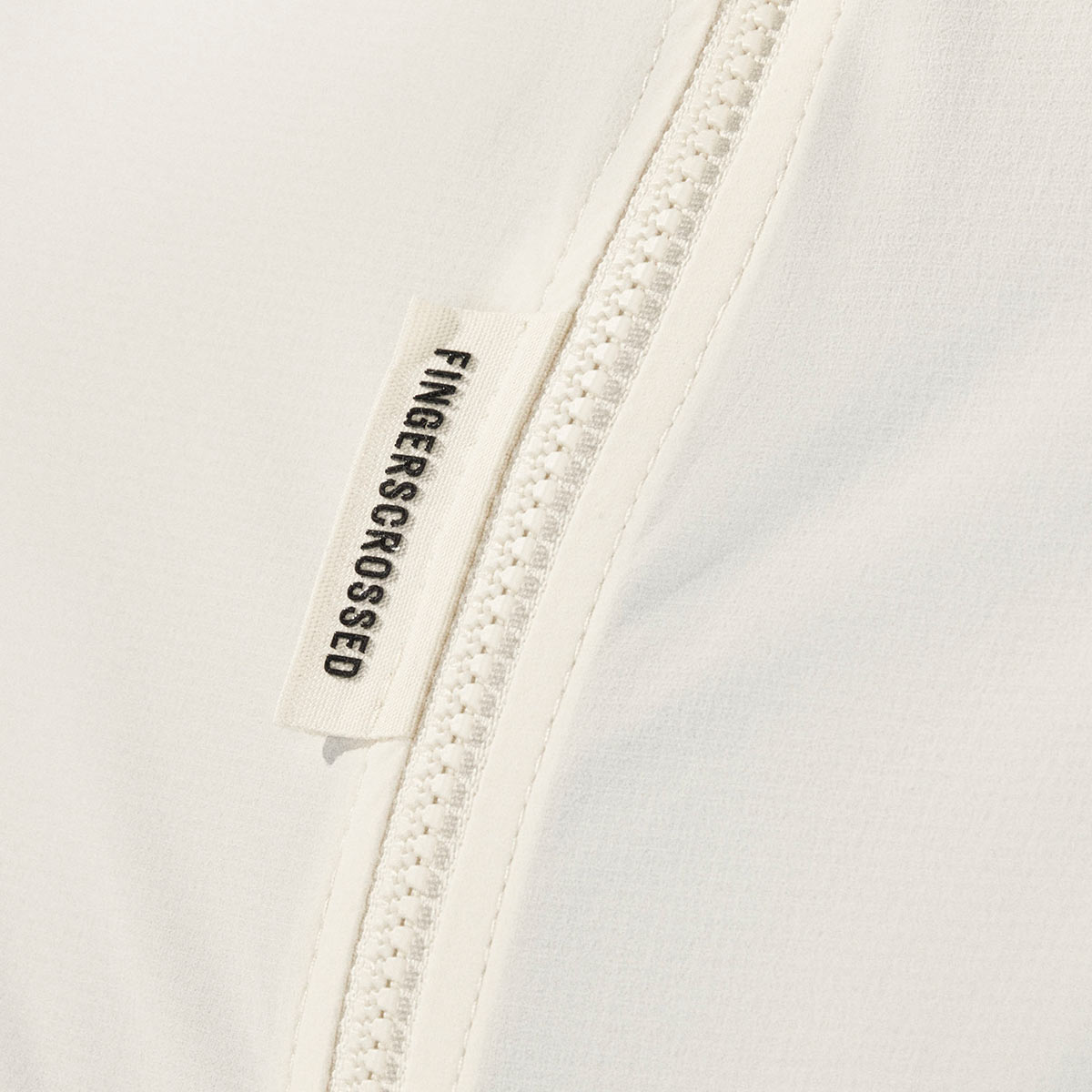 FINGERSCROSSED ROAD WIND JACKET MEN Windjacke Windbreaker Regenjacke Männer Radsport Rennrad antique cream weiss beige FINGERSCROSSED ROAD WIND JACKET MEN Windjacke Windbreaker Regenjacke Männer Radsport Rennrad antique cream weiss beige Detail reißverschluss Logo